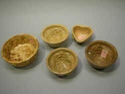 Four Small Yellowware Pudding Molds and a Rockingham Glaze Bowl. 